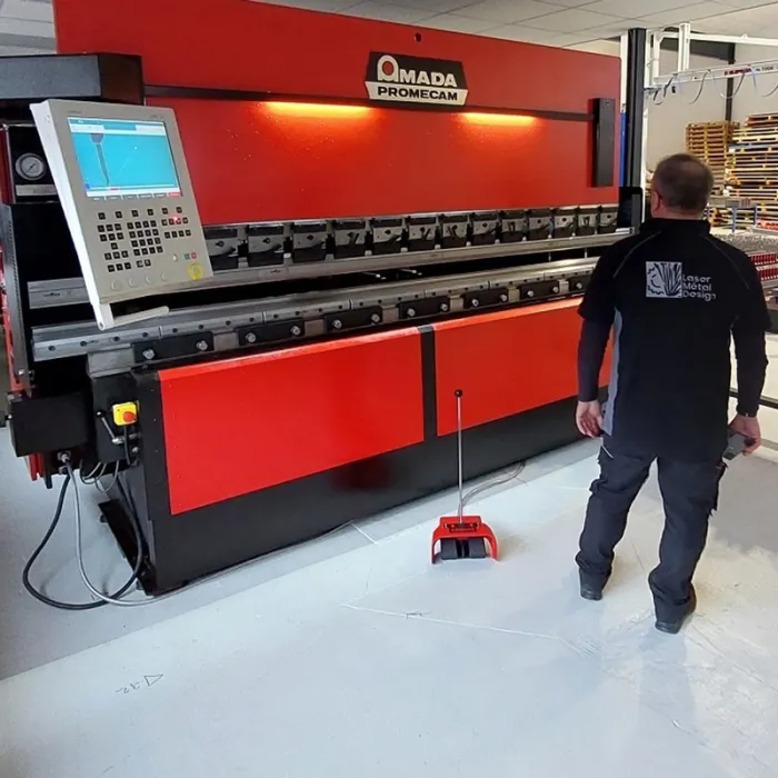 Opérateur devant une presse-plieuse Amada Promecam dans l'atelier de Laser Métal Design